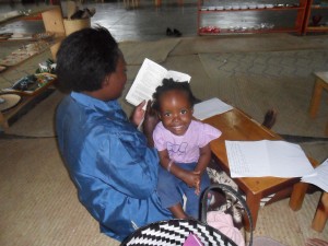 Jane Kabambe reading Maria Montessori-Her Life and Work, with our youngest diploma candidate, her daughter, Monica.